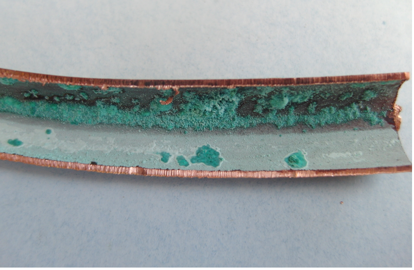 Corroded copper pipe interior showing green patina