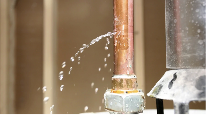 Active pinhole leak spraying water from copper pipe